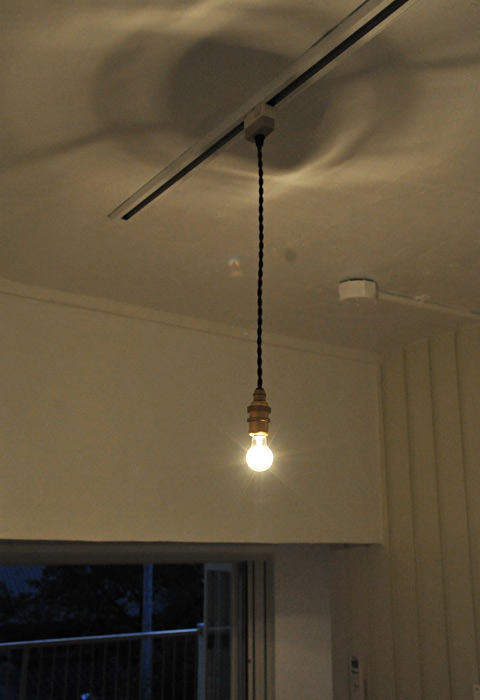 キッチンから部屋へ続くスペースの照明は裸電球がいい味。